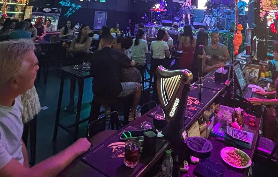 KQ's high tables facing the stage with the band playing, seen from behind the counter